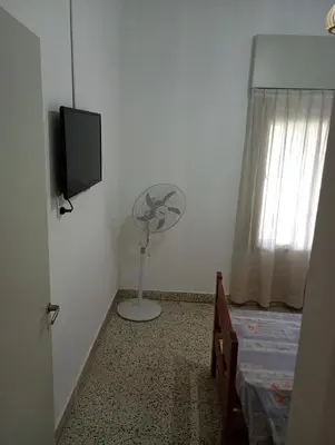 a bedroom with a bed and a fan and a television at Casa céntrica en villa Carlos Paz in Villa Carlos Paz