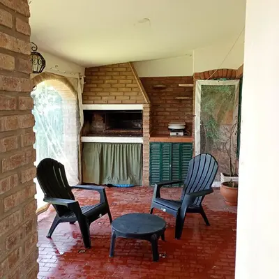 a room with three chairs and a table and a kitchen at Casa céntrica en villa Carlos Paz in Villa Carlos Paz