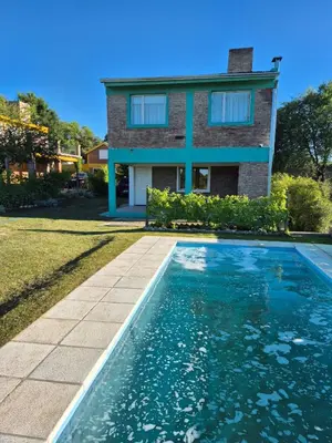 a house with a swimming pool in front of a house at Cabaña La Zarzamora in La Estancia
