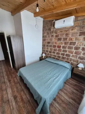 a bed in a room with a brick wall at Cabaña La Zarzamora in La Estancia