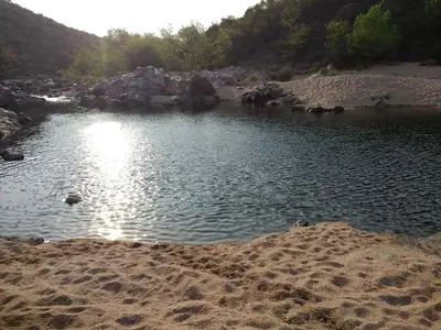 a body of water with rocks and a beach at Victoria in Villa Icho Cruz
