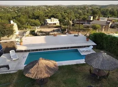 an outdoor swimming pool with two umbrellas next to it at casa lomas in San Antonio de Arredondo