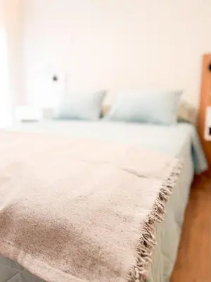 a close up of a bed with a blanket on it at Departamento de lujo frente al quality espacio in Cordoba