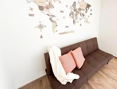 a couch in a room with a world map on the wall at Departamento de lujo frente al quality espacio in Cordoba
