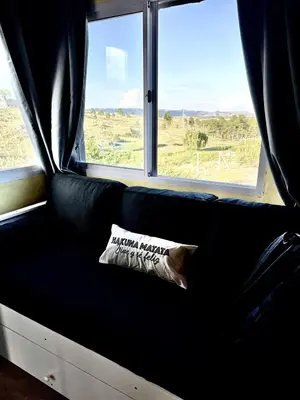 a black couch with a pillow in front of a window at Ecolodge in Potrero de Garay