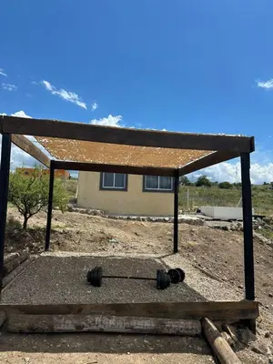 a building with a roof on top of a field at Ecolodge in Potrero de Garay