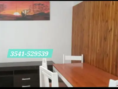 a dining room with a wooden table and chairs at Alquiler temporario exclusivo, siquiman in Villa Parque Siquiman