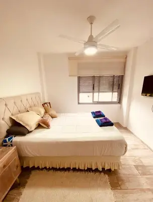 a bedroom with a large bed with a ceiling fan at Dpto Gral paz Tranquilo y comodo in Cordoba