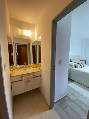 a bathroom with a sink and a mirror and a bed at Dpto Gral paz Tranquilo y comodo in Cordoba