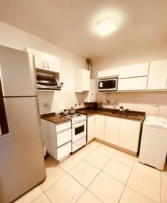 a kitchen with white cabinets and a refrigerator at Dpto Gral paz Tranquilo y comodo in Cordoba