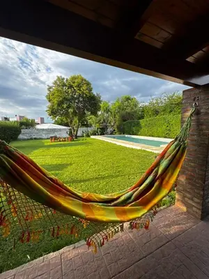 a hammock hanging from a porch next to a pool at Casa Simaldo in Villa Carlos Paz