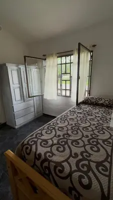 a bedroom with a large bed and two windows at Casa Simaldo in Villa Carlos Paz