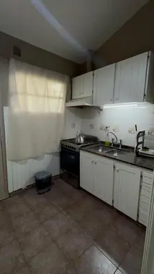 a small kitchen with a sink and a stove at Casa Simaldo in Villa Carlos Paz