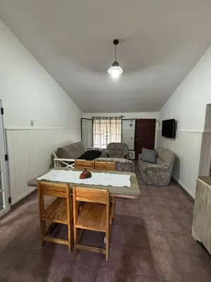 a living room with a table and a couch at Casa Simaldo in Villa Carlos Paz