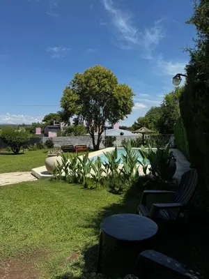 a yard with two chairs and a table and a tree at Casa Simaldo in Villa Carlos Paz