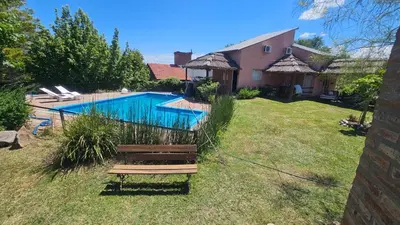 a backyard with a swimming pool and a house at Cabañas Likankurá in Santa Rosa de Calamuchita