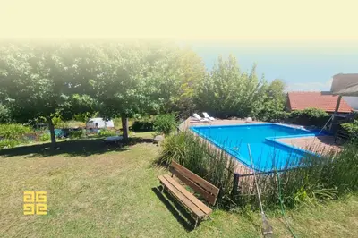 a swimming pool in a yard with a bench and trees at Cabañas Likankurá in Santa Rosa de Calamuchita
