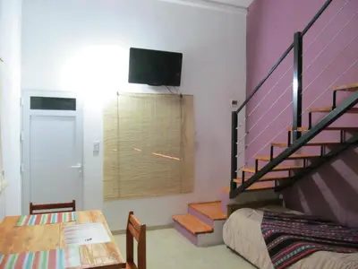 a room with a staircase and a bed and a table at Cabañas Likankurá in Santa Rosa de Calamuchita