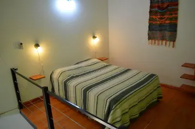 a bed in a room with two lights on at Cabañas Likankurá in Santa Rosa de Calamuchita