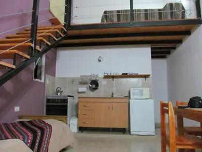 a kitchen with a staircase and a kitchen with a refrigerator at Cabañas Likankurá in Santa Rosa de Calamuchita