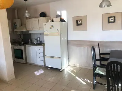 a kitchen with a white refrigerator and a table at Departamento con increible vista in Villa Carlos Paz