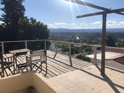 a balcony with a table and chairs on top of a building at Departamento con increible vista in Villa Carlos Paz