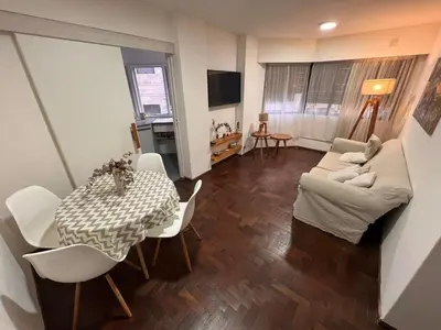 a living room with a table and white chairs at Departamento en Cordoba in Cordoba