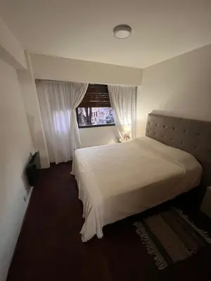 a bedroom with a large white bed with a window at Departamento en Cordoba in Cordoba