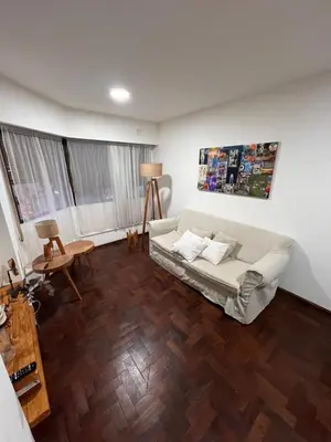 a living room with a white couch and wooden floors at Departamento en Cordoba in Cordoba