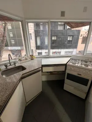 a kitchen with a stove and a sink and two windows at Departamento en Cordoba in Cordoba