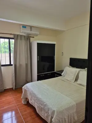 a bedroom with a large bed and a flat screen tv at Temporario Carlos Paz in Villa Carlos Paz