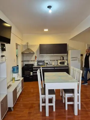 a kitchen with a white table and chairs in it at Temporario Carlos Paz in Villa Carlos Paz