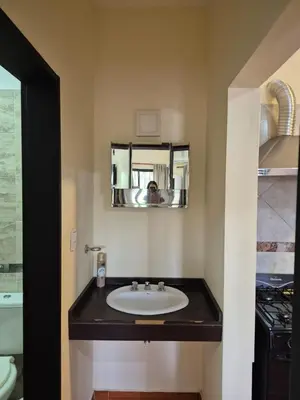 a bathroom with a sink and a person taking a picture at Temporario Carlos Paz in Villa Carlos Paz