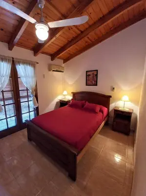 a bedroom with a large red bed with two lamps at ANELE, duplex equipado in Villa Carlos Paz