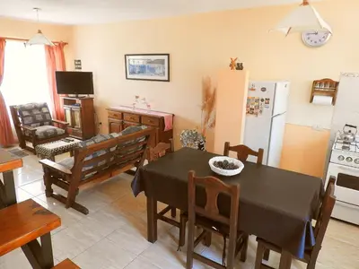 a kitchen and living room with a table and a refrigerator at ANELE, duplex equipado in Villa Carlos Paz