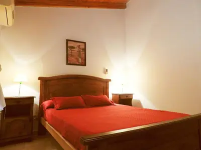 a bedroom with a bed with a red comforter at ANELE, duplex equipado in Villa Carlos Paz