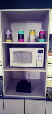 a shelf with a microwave and bowls on it at La Casita de Felipe in Santa Rosa de Calamuchita