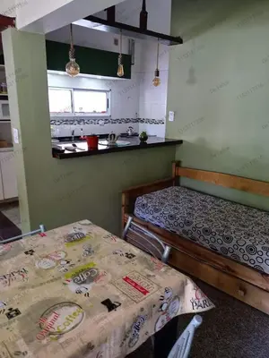 a room with two beds and a table in it at La Casita de Felipe in Santa Rosa de Calamuchita