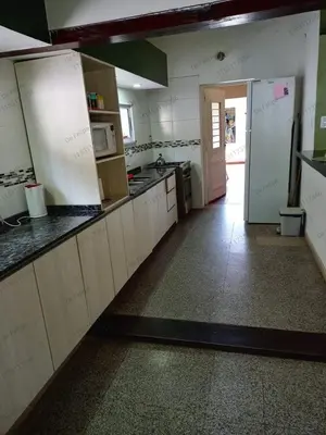 a large kitchen with white counters and a doorway at La Casita de Felipe in Santa Rosa de Calamuchita