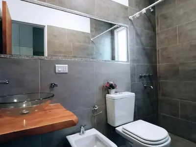 a bathroom with a toilet and a sink and a mirror at Lisandro in Villa Carlos Paz