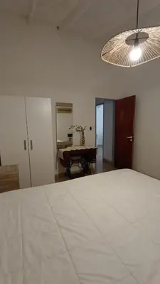 a bedroom with a bed and a table in a room at Lisandro in Villa Carlos Paz