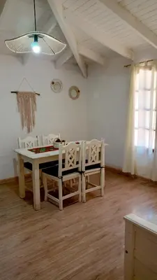 a dining room with a table and chairs and a window at Lisandro in Villa Carlos Paz