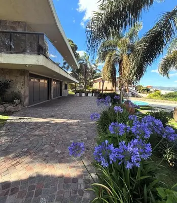 a house with purple flowers in front of it at CASA LG carlos paz in Villa Carlos Paz