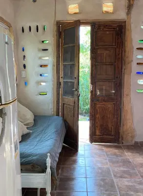 a bedroom with a bed in a room with doors at Icho's mud house in Villa Icho Cruz