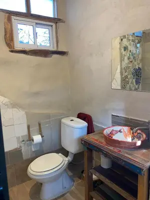 a bathroom with a toilet and a wooden table at Icho's mud house in Villa Icho Cruz