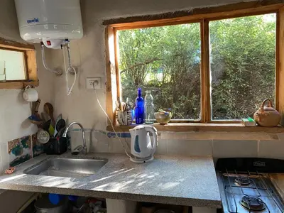 a kitchen counter with a sink and a window at Icho's mud house in Villa Icho Cruz