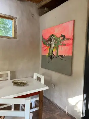 a painting of a bird on a wall next to a table at Icho's mud house in Villa Icho Cruz