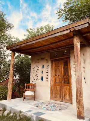 a house with a wooden door and a bench at Icho's mud house in Villa Icho Cruz