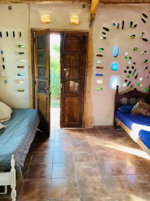 a room with two beds and shoes on the wall at Icho's mud house in Villa Icho Cruz