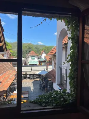 a window view of a courtyard with people sitting at tables at Posada Novalis in Villa General Belgrano